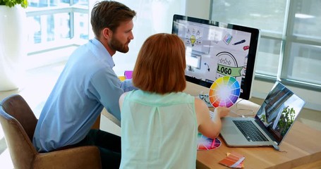 Graphic designers working at desk - Powered by Adobe