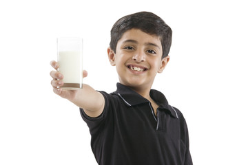 Young boy holding a glass of milk 