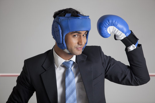 Businessman with boxing gloves raising his arm 
