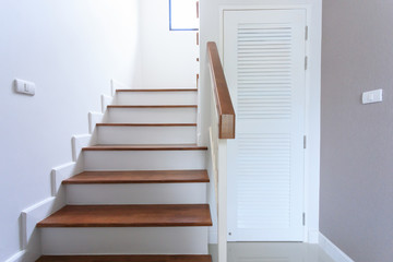 inside contemporary white modern house with wood staircase and pvc door