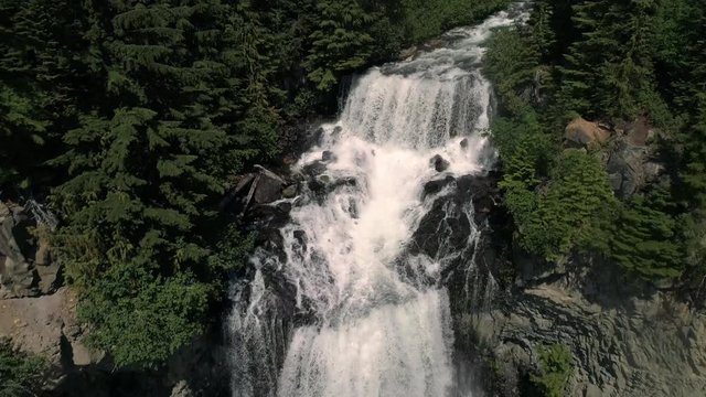 Drone Flying Backwards Down Waterfall in Colorful British Columbia Forest