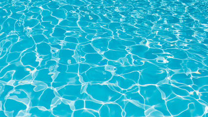 Blue and bright water surface and ripple wave with sun reflection in swimming pool