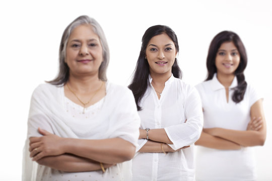Multi generation family with arms crossed over white background 