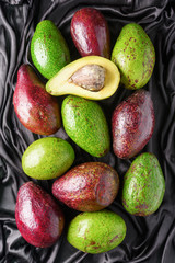 Different colors and cultivars of avocado. Green and red fruits
