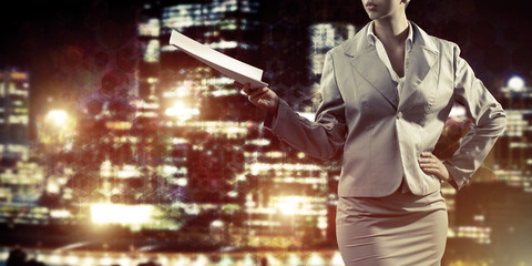 Close of businesswoman against night cityscape background and te