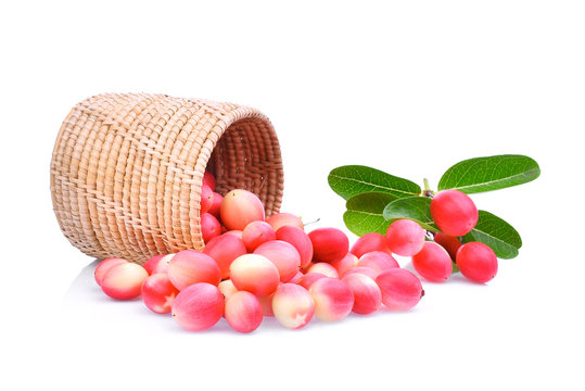 karanda or carunda tropical fruit in wooden basket with green leaves isolated on white background