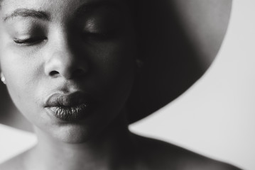 woman in hat closes her eyes peacefully