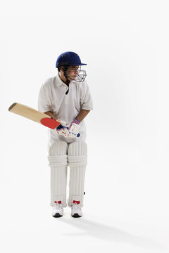 Young man playing cricket isolated over white background 