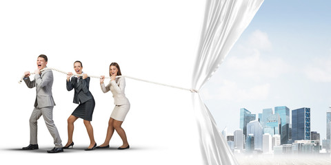 Obraz premium Young businesspeople working in collaboration and pulling white advertisement banner