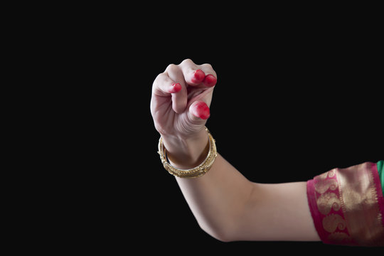 Close-up of a woman's hand making Bharatanatyam gesture called Kangula on black background