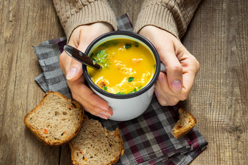  hands holding mug of soup