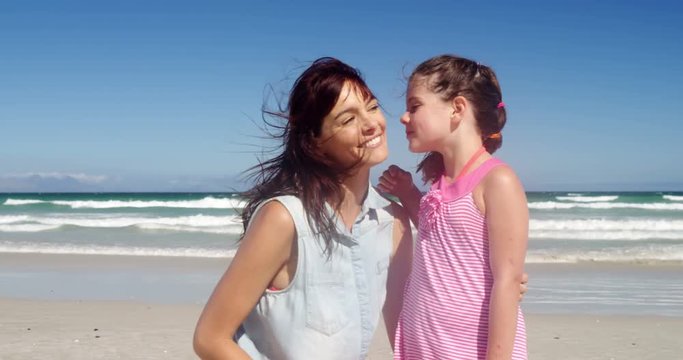 Affectionate daughter kissing her mother at beach