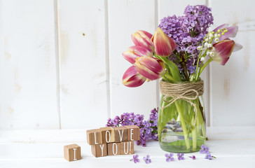 Message I love you spelled in wooden blocks and spring bouquet with tulips