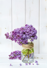 bouquet of purple lilac on a white  wooden background with space for message.