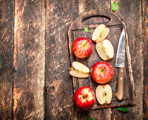 Fresh apples on a cutting Board with a knife.
