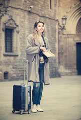 traveling girl searching for the direction using a booklet in the town