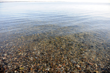 spiegelglatte klare wasseroberfläche über kies