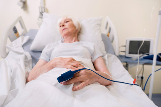 Tender sick woman wearing pulsimeter