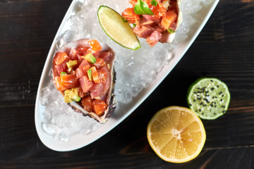 Delicious red fish in the shells of shellfish. With lemon and lime jpg