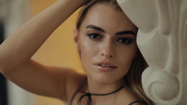 Attractive sexy fashion model closeup portrait in a city street, slow motion