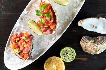 Delicious red fish in the shells of shellfish. With lemon and lime jpg