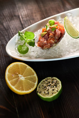 Delicious red fish in the shells of shellfish. With lemon and lime jpg