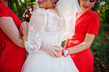 Gentle bride and beautiful bridesmaids are having great fun in the park on a sunny wedding day.