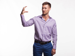 Young surprised man portrait of a confident businessman showing by hands on a gray background. Ideal for banners, registration forms, presentation, landings, presenting concept.