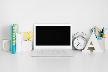 Workplace with laptop on white table, business or education concept