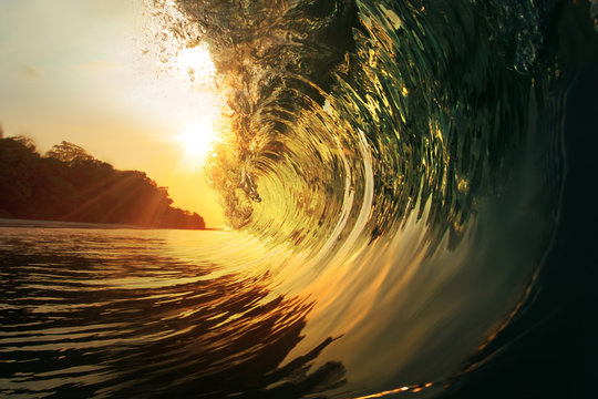 rough colored ocean wave falling down at sunset time