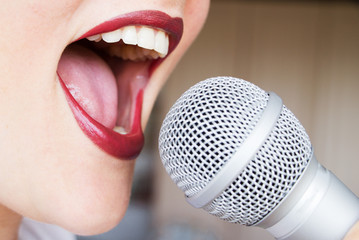 Open female mouth with microphone