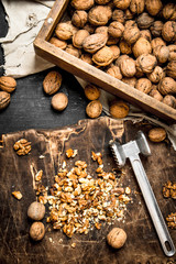 Crushed walnuts with a hammer on the old Board.