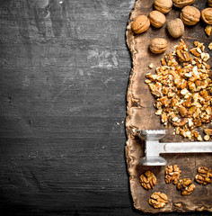 Crushed walnuts with a hammer on the old Board.