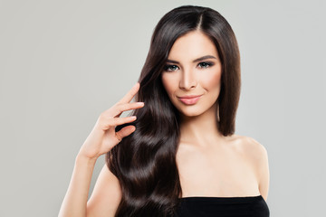 Fototapeta premium Haircare Concept. Cute Brunette Woman with Natural Perfect Hairstyle and Makeup. Beautiful Model with Long Healthy Hair