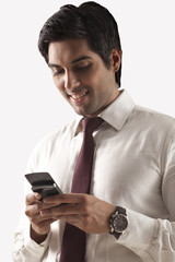 Confident young man text messaging on white background 