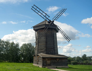 Fototapeta na wymiar Old wooden windmill in Suzdal, Russia. The windmill's blades act like a rotating fan which pushes the rod attached to it to the direction the wind is blowing. 
