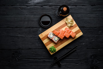 Japanese cuisine. Salmon sushi roll (philadelphia) over dark wooden background