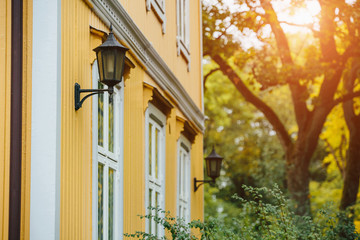 Fototapeta na wymiar Wall of a yellow wooden house with a lantern