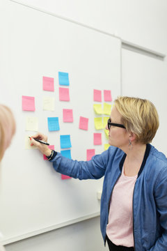 Woman writes on post-it pieces