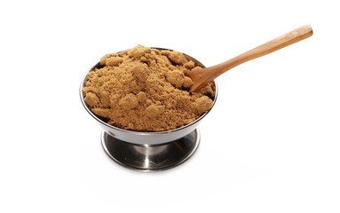 Unrefined light brown cane sugar pile in metal bowl with wooden spoon isolated on white background