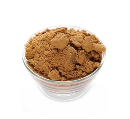 Unrefined light brown cane sugar pile in glass bowl isolated on white background