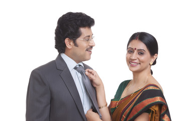 Wife fastening husband's tie