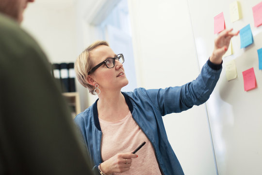 Woman pointing at whiteboard