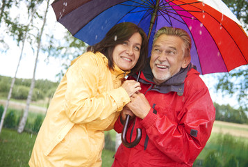 Senior couple sharing an umbrella in the rain