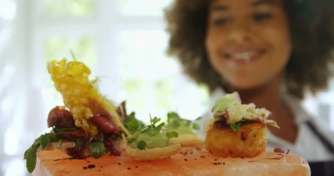 Smiling waitress holding food tray