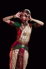 Furious Bharatanatyam dancer performing over black background