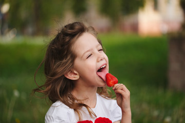 beautiful girl eating big juicy strawberry