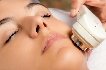 Ultrasonic facial treatment on woman. - obrazy, fototapety, plakaty