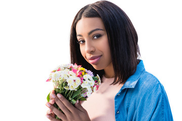 beautiful african american girl holding bouquet of flowers and smiling at camera isolated on white