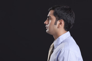 Profile shot of businessman against black background